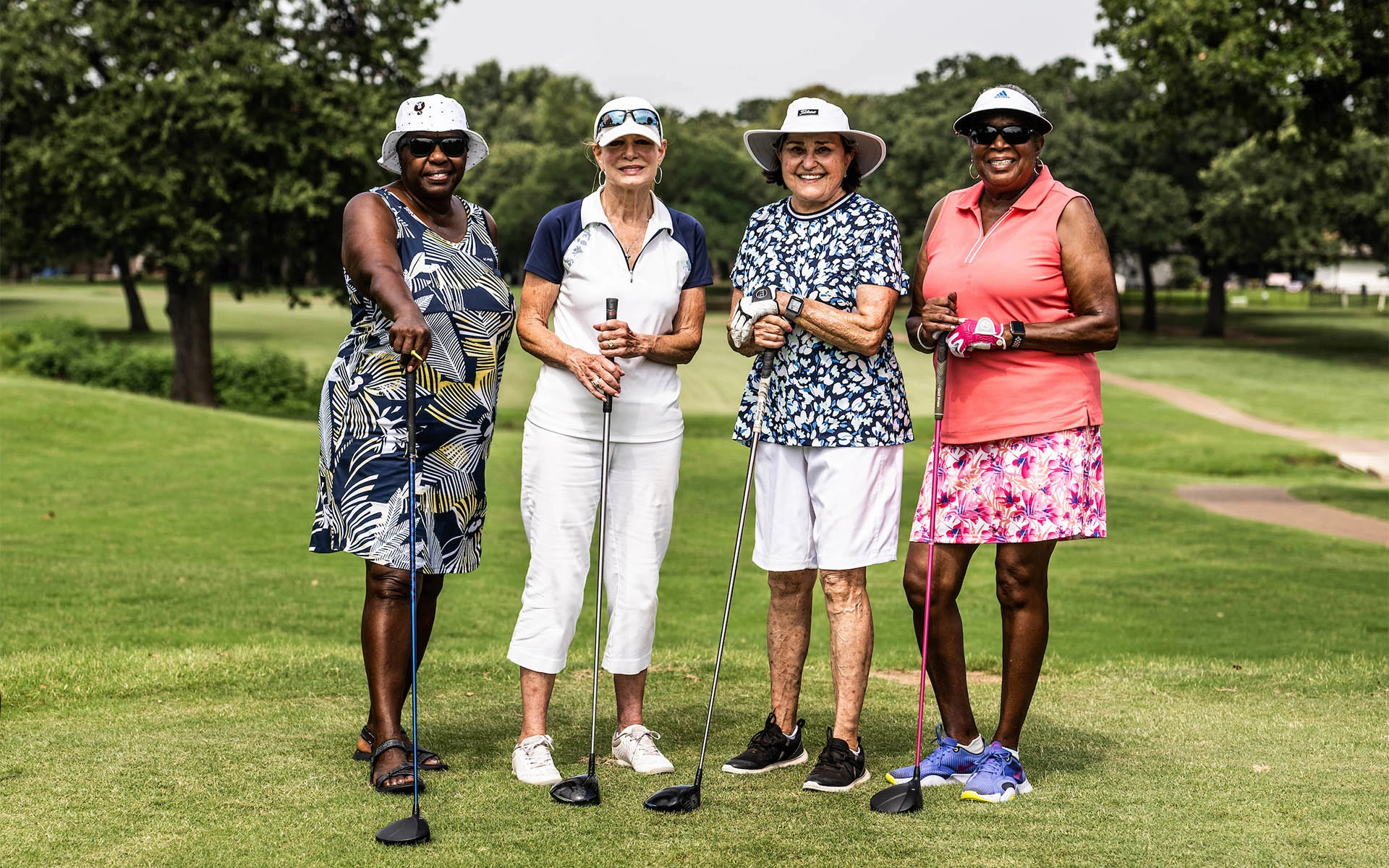 Four women golfers on the tee at an Invited Club golf course.